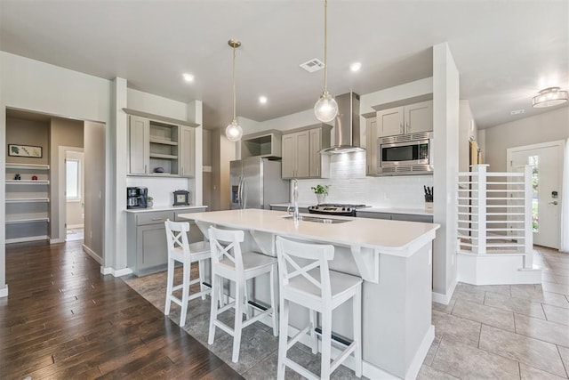 637 NW 179th Cir, Edmond, OK 73012 - kitchen featuring appliances with stainless steel finishes, gray cabinetry, wall chimney exhaust hood, open shelves, and recessed lighting