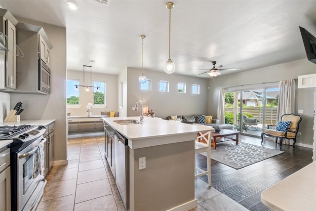 637 NW 179th Cir, Edmond, OK 73012 - kitchen featuring stainless steel appliances, light countertops, healthy amount of natural light, and a ceiling fan