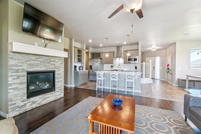 637 NW 179th Cir, Edmond, OK 73012 - living area featuring dark wood-style floors, ceiling fan, recessed lighting, and a stone fireplace