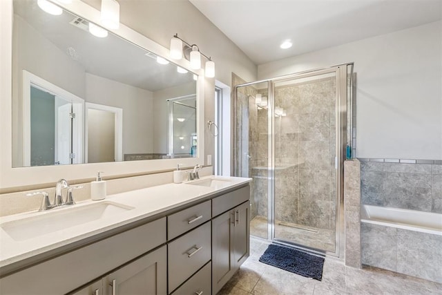 637 NW 179th Cir, Edmond, OK 73012 - full bathroom with double vanity, a garden tub, a stall shower, and tile patterned floors