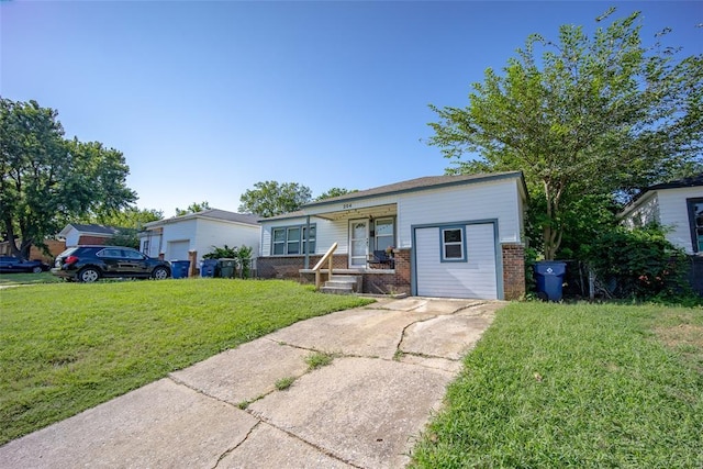 204 E Elder Ave, Duncan, OK 73533 - view of front facade with brick siding, a front yard, covered porch, and driveway