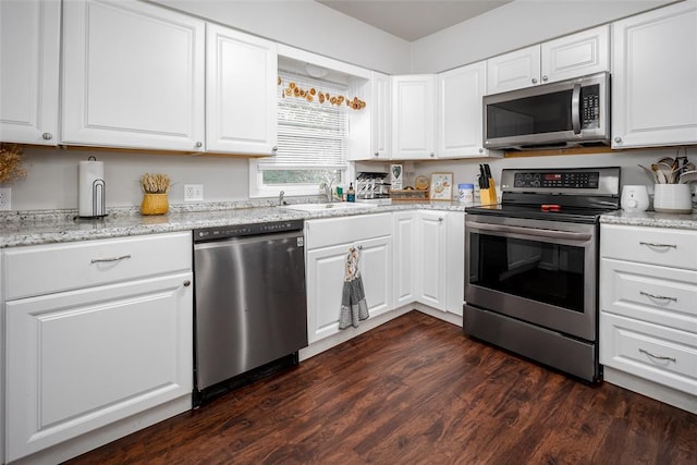 204 E Elder Ave, Duncan, OK 73533 - kitchen featuring appliances with stainless steel finishes, white cabinetry, dark wood-style floors, and light stone countertops