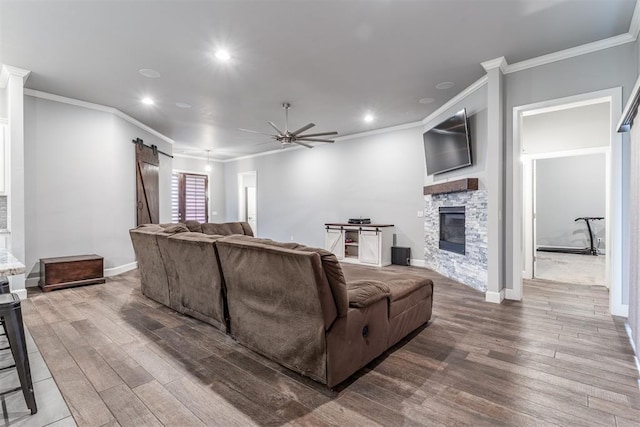 9125 NE Mustang Rd, Piedmont, OK 73078 - living area featuring a barn door, a ceiling fan, wood finished floors, ornamental molding, and recessed lighting