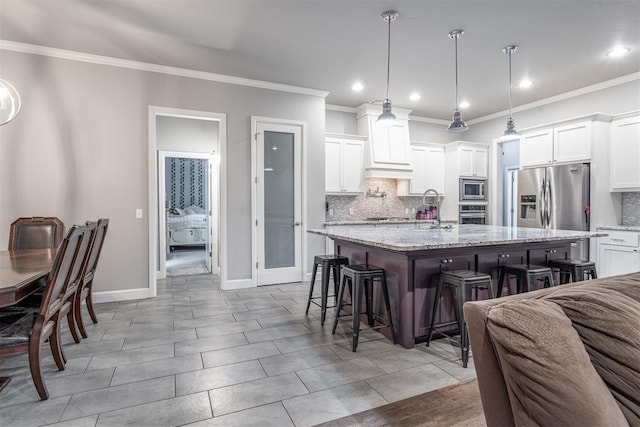 9125 NE Mustang Rd, Piedmont, OK 73078 - kitchen with stainless steel appliances, a breakfast bar, decorative backsplash, crown molding, and a center island with sink