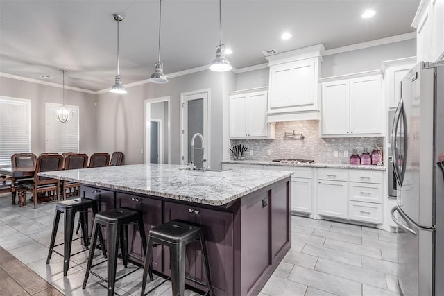 9125 NE Mustang Rd, Piedmont, OK 73078 - kitchen with appliances with stainless steel finishes, tasteful backsplash, crown molding, white cabinets, and a kitchen breakfast bar