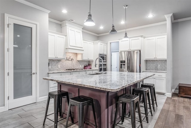 9125 NE Mustang Rd, Piedmont, OK 73078 - kitchen with appliances with stainless steel finishes, a breakfast bar area, crown molding, tasteful backsplash, and white cabinetry
