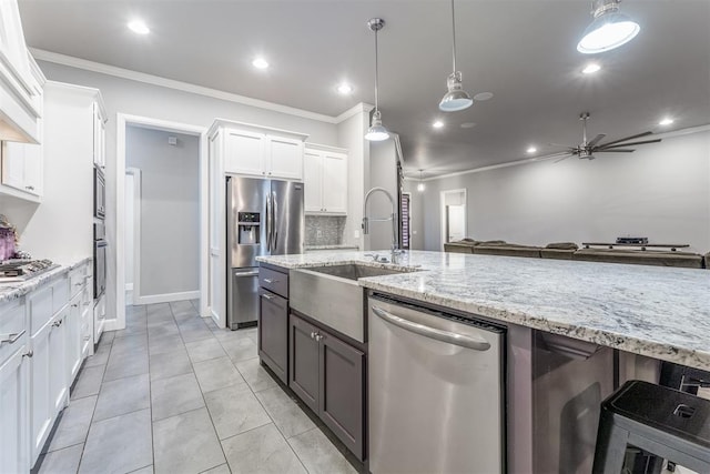 9125 NE Mustang Rd, Piedmont, OK 73078 - kitchen featuring stainless steel appliances, ornamental molding, white cabinets, ceiling fan, and light stone countertops