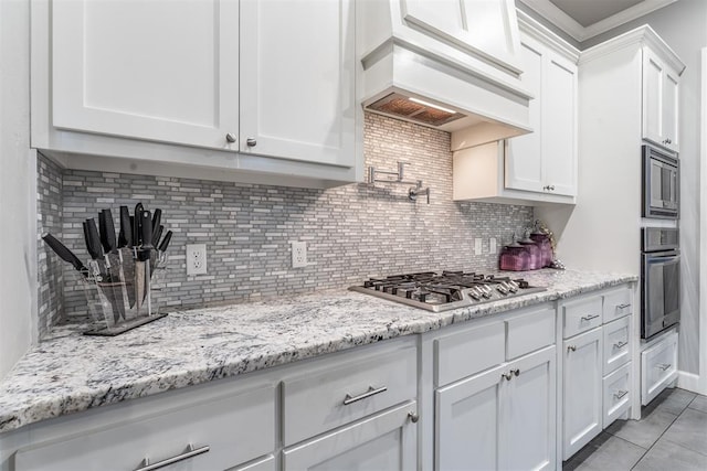 9125 NE Mustang Rd, Piedmont, OK 73078 - kitchen with stainless steel appliances, white cabinetry, decorative backsplash, and crown molding