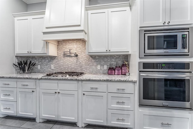9125 NE Mustang Rd, Piedmont, OK 73078 - kitchen featuring stainless steel appliances, white cabinets, tasteful backsplash, premium range hood, and light stone counters