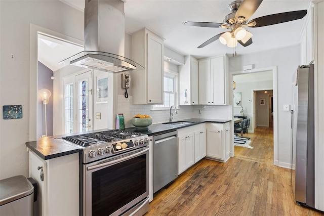 2625 Somerset Pl, Oklahoma City, OK 73116 - kitchen with appliances with stainless steel finishes, range hood, dark countertops, white cabinets, and backsplash