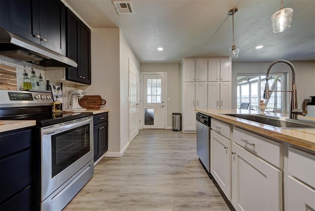 201 N English Dr, Moore, OK 73160 - kitchen featuring stainless steel appliances, under cabinet range hood, light wood-type flooring, backsplash, and recessed lighting
