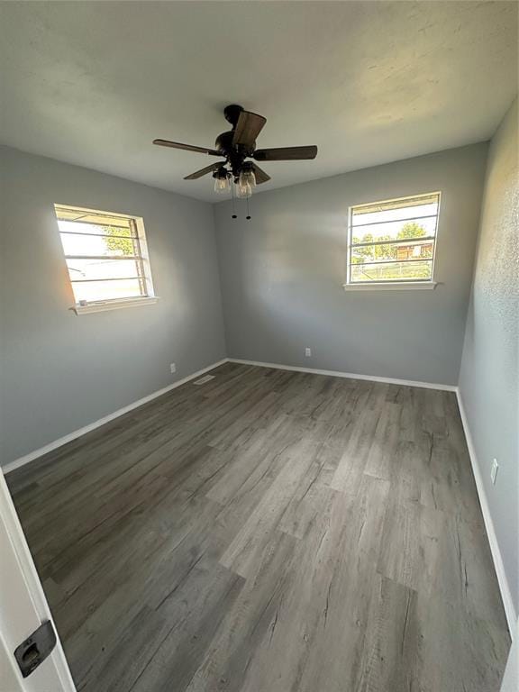 1501 W Watts St, El Reno, OK 73036 - empty room featuring wood finished floors, healthy amount of natural light, and a ceiling fan