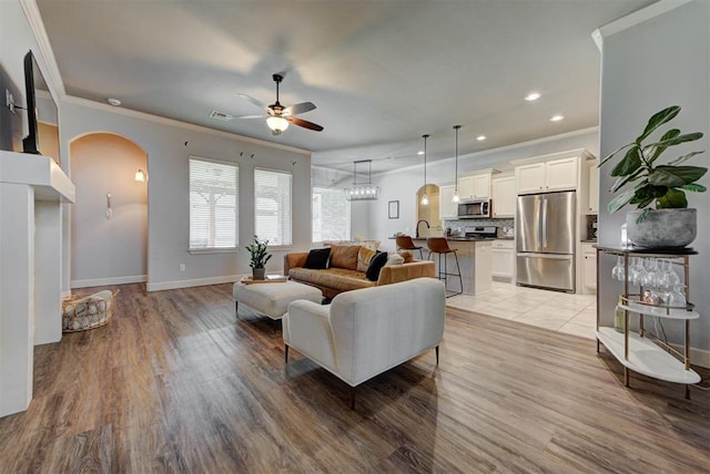 9920 NW 142nd St, Yukon, OK 73099 - living area with ceiling fan, crown molding, arched walkways, recessed lighting, and light wood-style floors