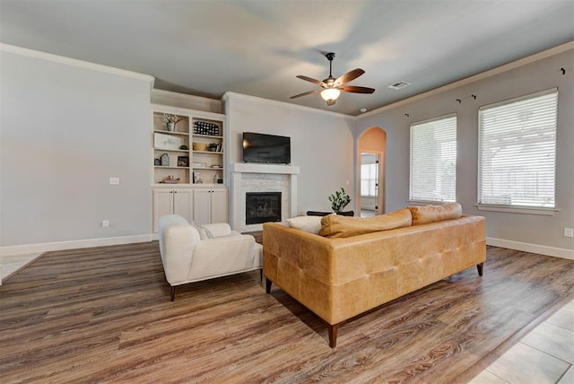 9920 NW 142nd St, Yukon, OK 73099 - living room featuring a ceiling fan, a glass covered fireplace, arched walkways, ornamental molding, and wood finished floors