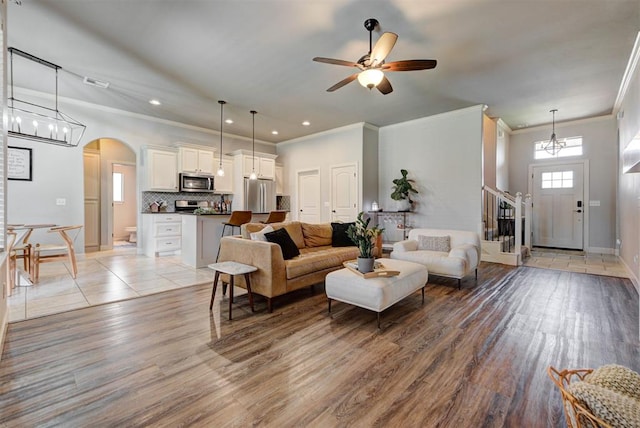 9920 NW 142nd St, Yukon, OK 73099 - living area with crown molding, light wood finished floors, ceiling fan, arched walkways, and recessed lighting