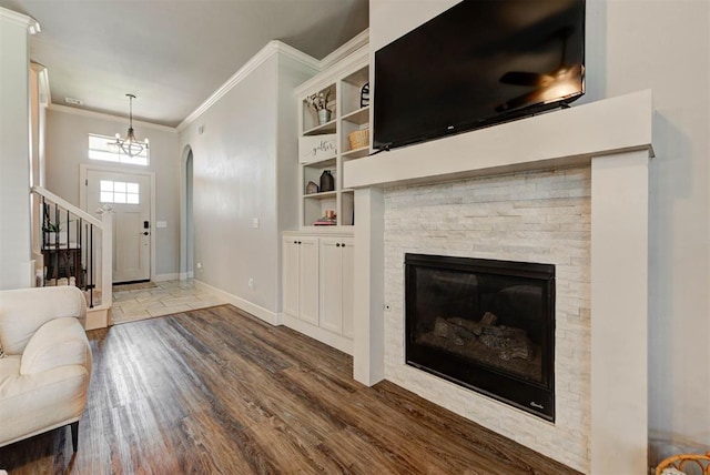 9920 NW 142nd St, Yukon, OK 73099 - entrance foyer with wood finished floors, ornamental molding, a stone fireplace, stairs, and a chandelier