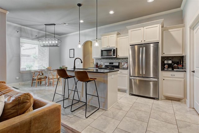 9920 NW 142nd St, Yukon, OK 73099 - kitchen featuring stainless steel appliances, tasteful backsplash, ornamental molding, a center island with sink, and a breakfast bar area