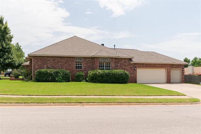 1723 Grey Hawk Rd, Edmond, OK 73003 - view of front of house with a garage, driveway, a front yard, brick siding, and roof with shingles