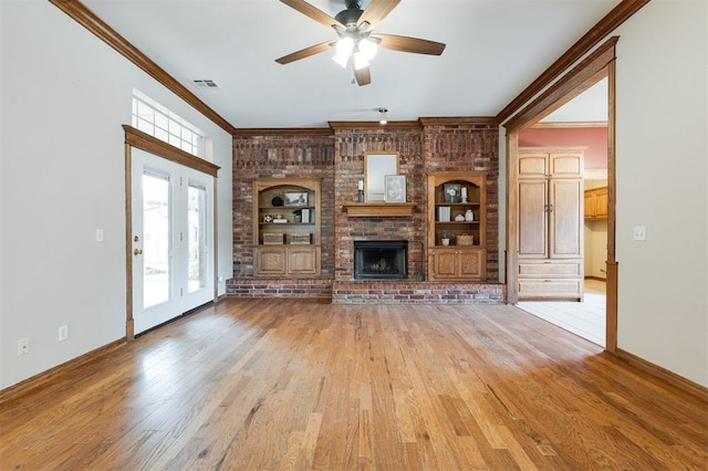 1723 Grey Hawk Rd, Edmond, OK 73003 - unfurnished living room featuring crown molding, built in features, light wood finished floors, a ceiling fan, and a brick fireplace