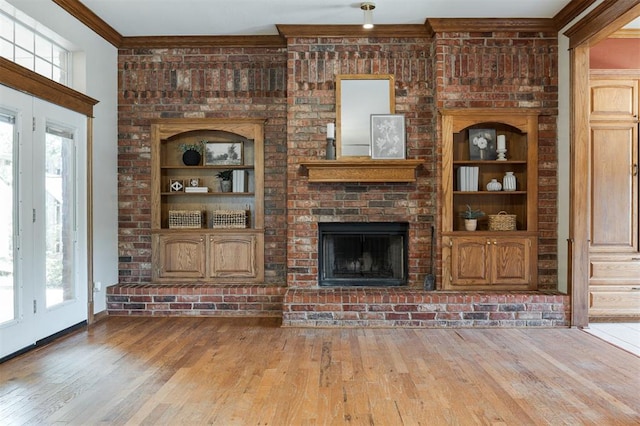 1723 Grey Hawk Rd, Edmond, OK 73003 - unfurnished living room with crown molding, wood-type flooring, plenty of natural light, and a fireplace