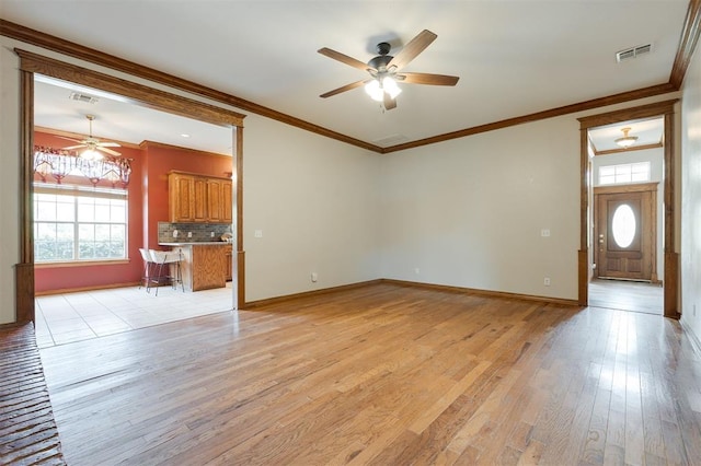 1723 Grey Hawk Rd, Edmond, OK 73003 - unfurnished living room featuring ceiling fan, healthy amount of natural light, ornamental molding, and light wood finished floors