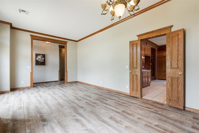 1723 Grey Hawk Rd, Edmond, OK 73003 - empty room featuring light wood-style flooring, a chandelier, and ornamental molding