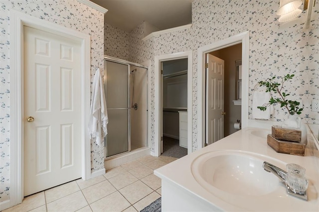 1723 Grey Hawk Rd, Edmond, OK 73003 - bathroom with wallpapered walls, tile patterned floors, a shower stall, double vanity, and a walk in closet