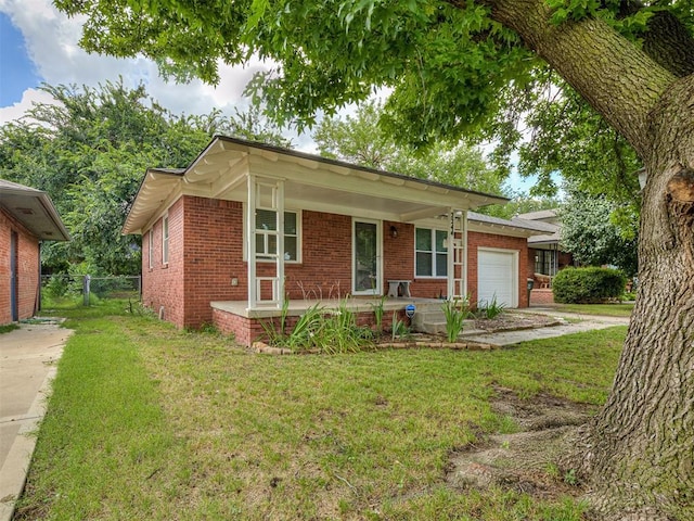 2244 Downing St, Oklahoma City, OK 73120 - ranch-style house featuring brick siding, covered porch, an attached garage, and driveway