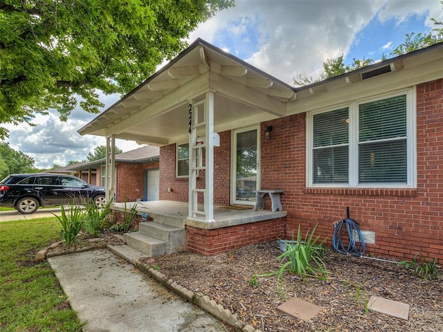 2244 Downing St, Oklahoma City, OK 73120 - property entrance with a porch and brick siding
