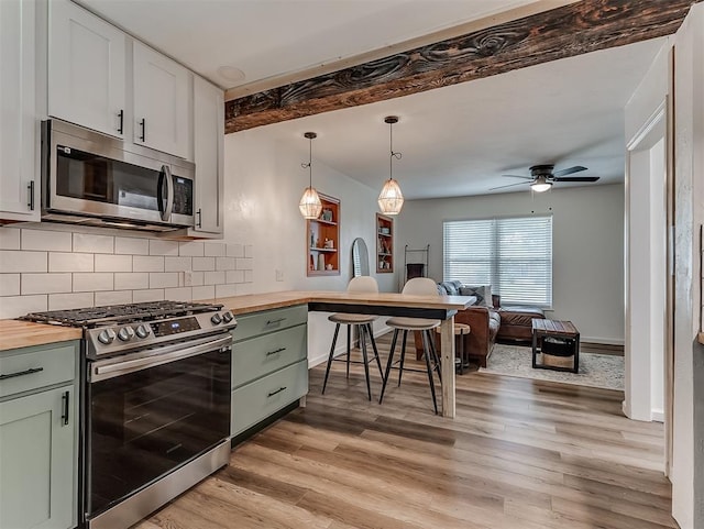 2244 Downing St, Oklahoma City, OK 73120 - kitchen with appliances with stainless steel finishes, butcher block counters, green cabinetry, tasteful backsplash, and beamed ceiling