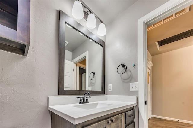 2208 Rivera Rd, Yukon, OK 73099 - bathroom featuring vanity, wood finished floors, and a textured wall