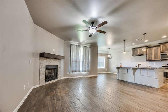 2208 Rivera Rd, Yukon, OK 73099 - unfurnished living room featuring a ceiling fan, wood finished floors, a fireplace, and recessed lighting