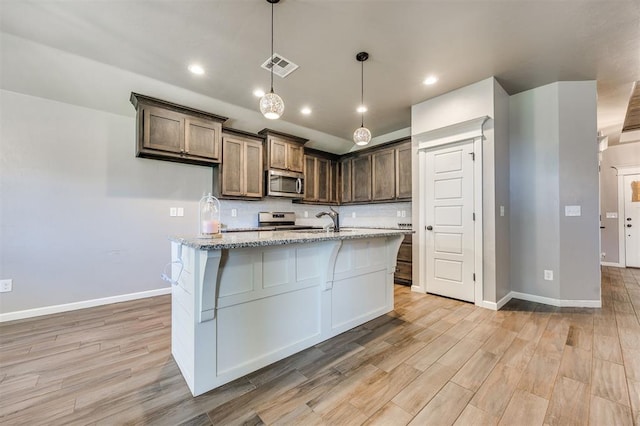 2208 Rivera Rd, Yukon, OK 73099 - kitchen featuring stainless steel appliances, light wood-style flooring, light stone counters, tasteful backsplash, and recessed lighting