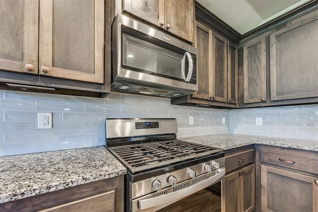 2208 Rivera Rd, Yukon, OK 73099 - kitchen featuring stainless steel appliances, tasteful backsplash, dark brown cabinetry, and light stone counters