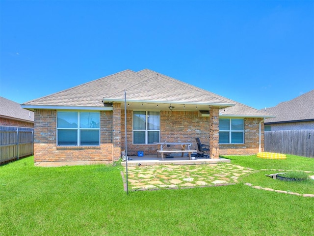2208 Rivera Rd, Yukon, OK 73099 - back of house featuring brick siding, roof with shingles, and a patio area