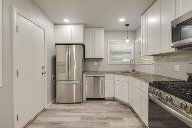 1627 Sheffield Rd, Oklahoma City, OK 73120 - kitchen featuring stainless steel appliances, light stone counters, white cabinetry, decorative backsplash, and light wood-type flooring