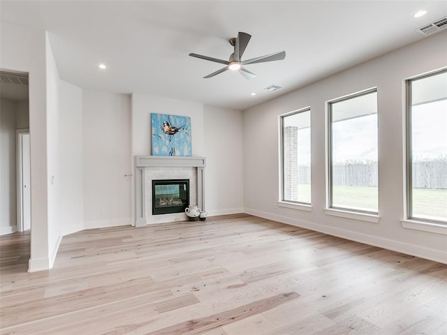 208 Pont Neuf Ct, Edmond, OK 73034 - unfurnished living room with ceiling fan, light wood-type flooring, a glass covered fireplace, and recessed lighting