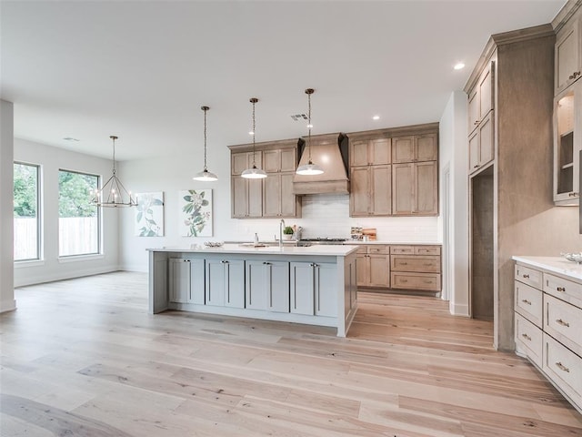 208 Pont Neuf Ct, Edmond, OK 73034 - kitchen featuring premium range hood, light countertops, light wood-type flooring, a chandelier, and recessed lighting