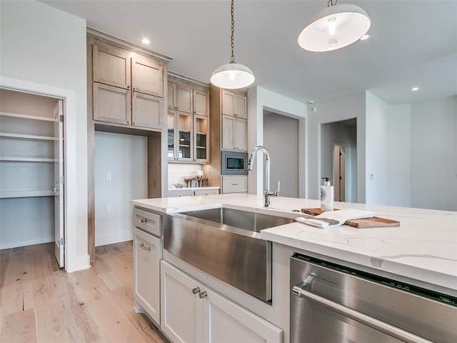 208 Pont Neuf Ct, Edmond, OK 73034 - kitchen featuring stainless steel appliances, light wood-style floors, decorative light fixtures, light stone countertops, and decorative backsplash
