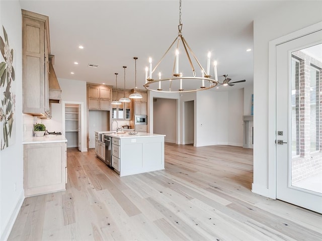 208 Pont Neuf Ct, Edmond, OK 73034 - kitchen featuring stainless steel appliances, light countertops, open floor plan, a chandelier, and light wood-style flooring