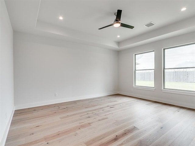 208 Pont Neuf Ct, Edmond, OK 73034 - spare room featuring a tray ceiling, light wood-type flooring, ceiling fan, and recessed lighting