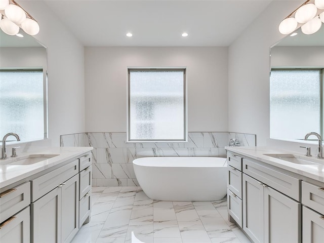 208 Pont Neuf Ct, Edmond, OK 73034 - full bathroom with tile walls, two vanities, a freestanding bath, wainscoting, and recessed lighting