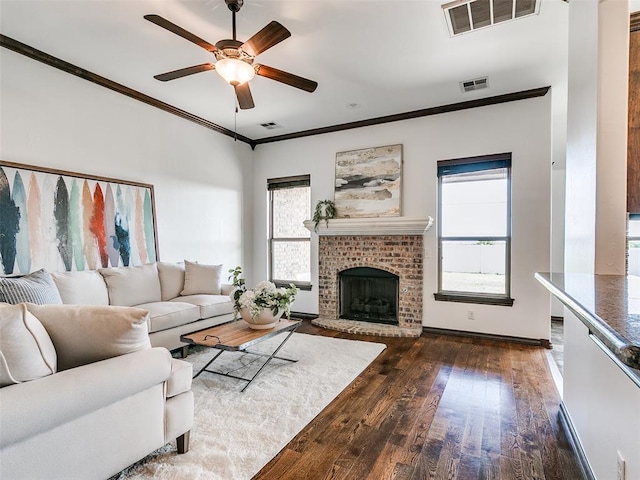 3205 NW 192nd Ter, Edmond, OK 73012 - living area featuring healthy amount of natural light, ceiling fan, wood finished floors, ornamental molding, and a brick fireplace