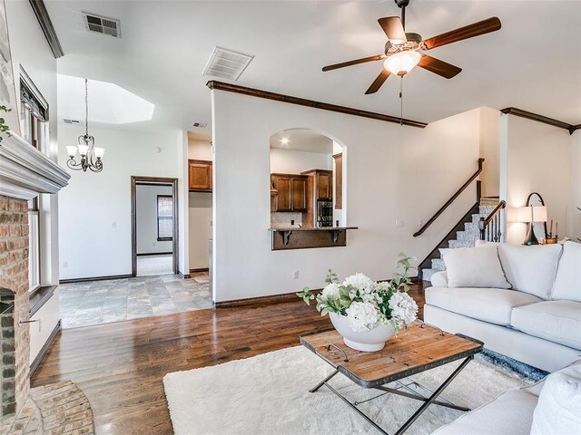 3205 NW 192nd Ter, Edmond, OK 73012 - living area featuring light wood-style flooring, a ceiling fan, stairway, arched walkways, and a chandelier