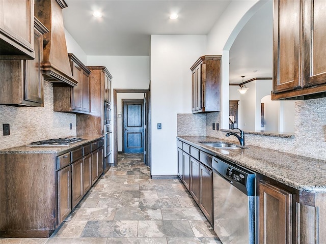 3205 NW 192nd Ter, Edmond, OK 73012 - kitchen with stainless steel appliances, arched walkways, light stone countertops, backsplash, and custom range hood
