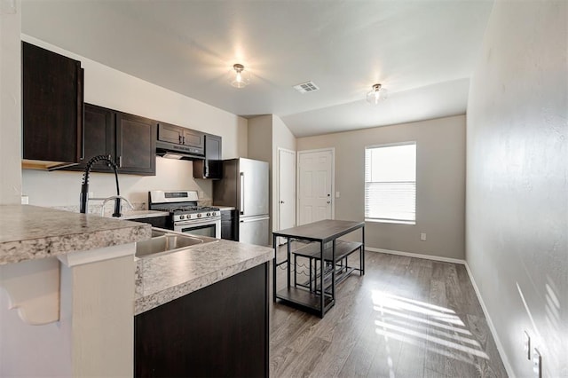 1621 Tumbleweed Way, El Reno, OK 73036 - kitchen with appliances with stainless steel finishes, light countertops, light wood-type flooring, and dark brown cabinets
