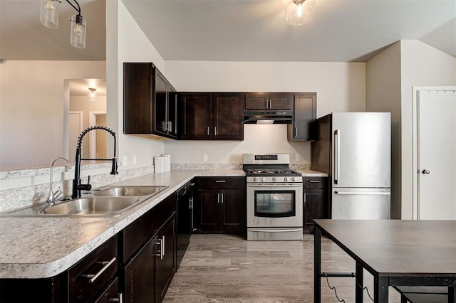 1621 Tumbleweed Way, El Reno, OK 73036 - kitchen with appliances with stainless steel finishes, under cabinet range hood, light wood-type flooring, dark brown cabinetry, and light countertops