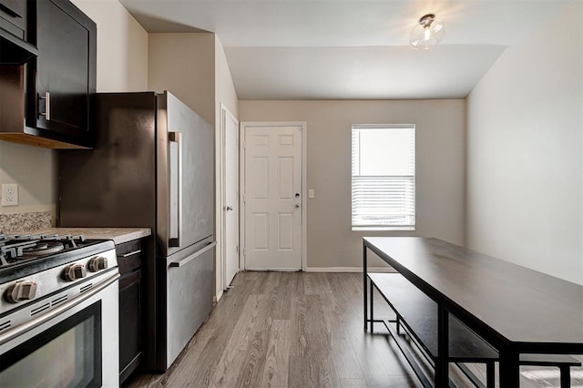 1621 Tumbleweed Way, El Reno, OK 73036 - kitchen with light wood-style flooring, light countertops, gas range, and dark cabinetry
