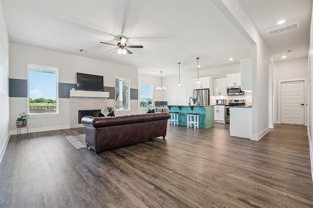 2316 Dixie Dr, Blanchard, OK 73010 - living room featuring a ceiling fan, dark wood-style flooring, a brick fireplace, and recessed lighting