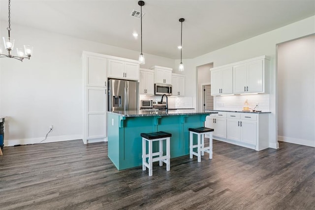 2316 Dixie Dr, Blanchard, OK 73010 - kitchen with stainless steel appliances, a chandelier, tasteful backsplash, and dark wood-style floors